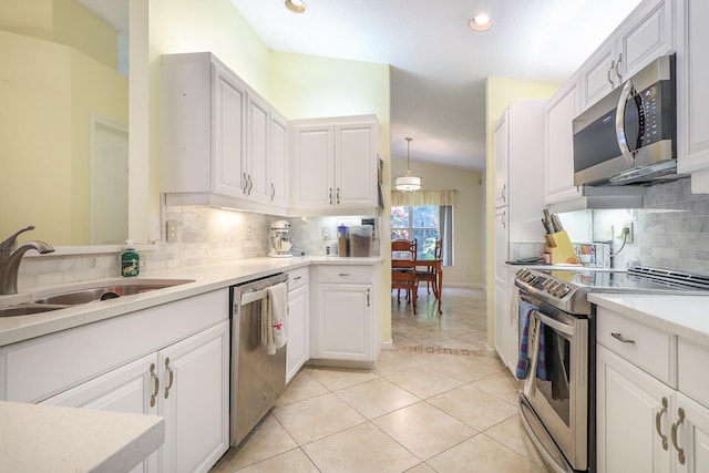 kitchen with backsplash, vaulted ceiling, and appliances with stainless steel finishes