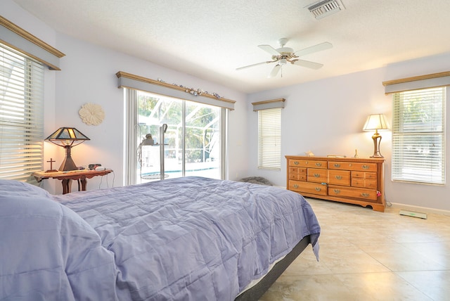 bedroom with access to outside, a textured ceiling, light tile flooring, and ceiling fan