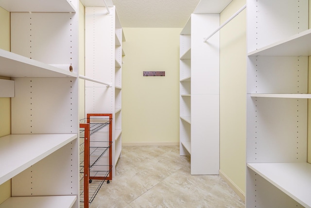 walk in closet with light tile flooring