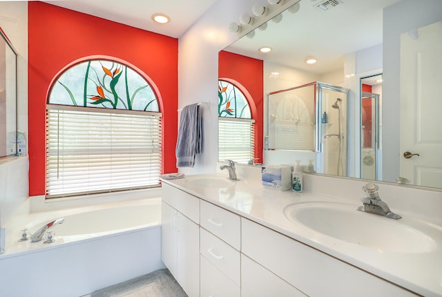 bathroom with dual bowl vanity and separate shower and tub