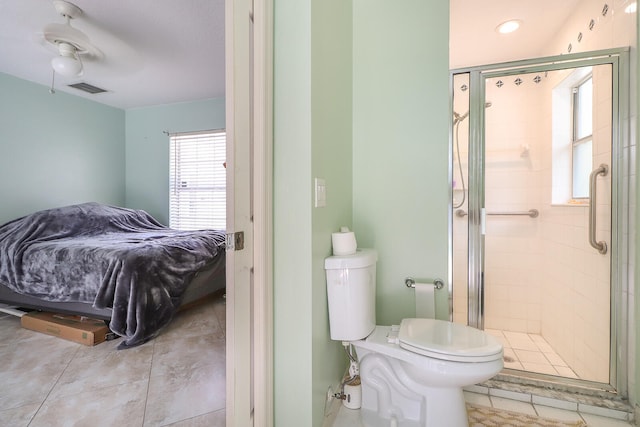 bathroom with tile floors, a shower with door, ceiling fan, and toilet