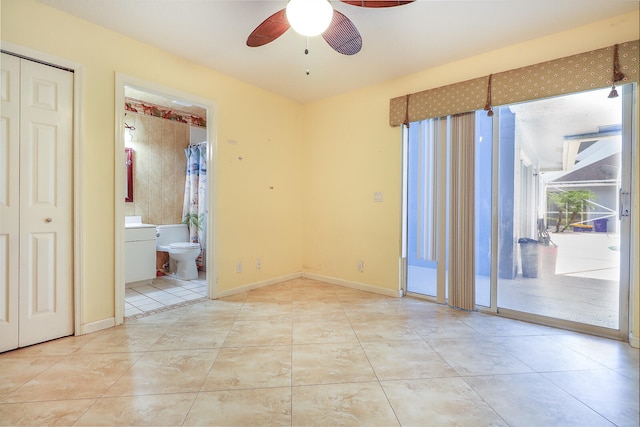 unfurnished bedroom with ceiling fan, ensuite bath, and light tile floors