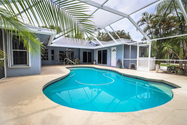 view of swimming pool featuring a patio area and glass enclosure