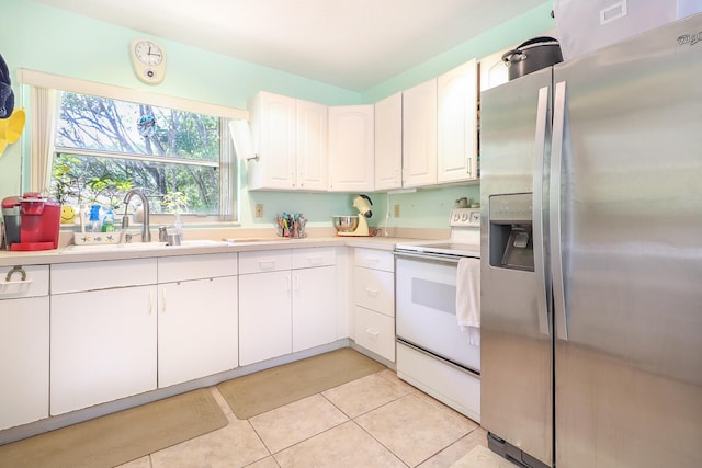 kitchen featuring stainless steel fridge, white electric range oven, light tile floors, sink, and white cabinetry