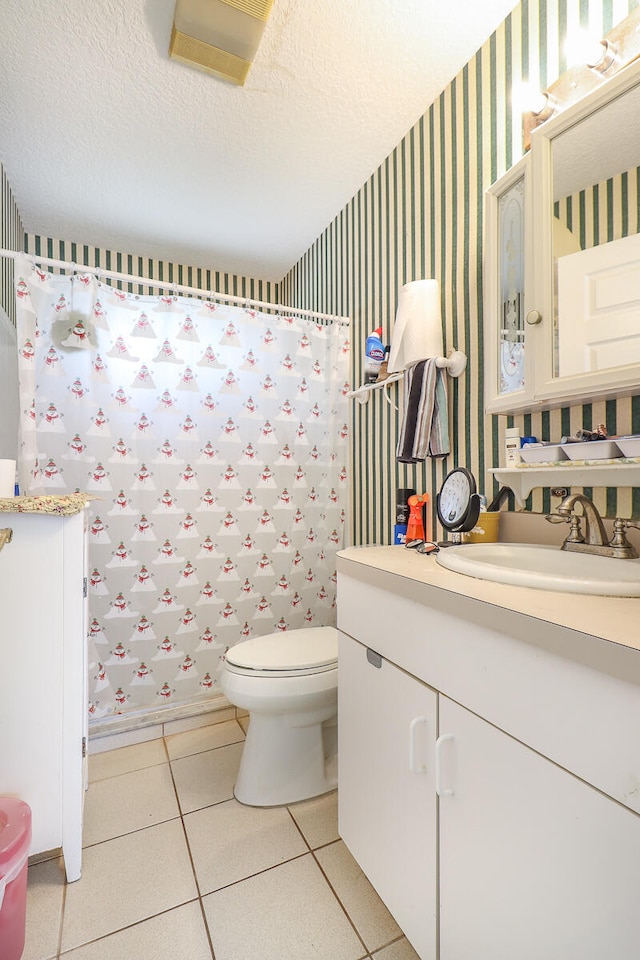 bathroom featuring tile floors, a textured ceiling, toilet, and vanity