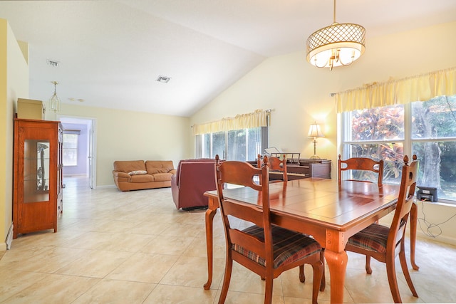 dining room with plenty of natural light, light tile flooring, and vaulted ceiling