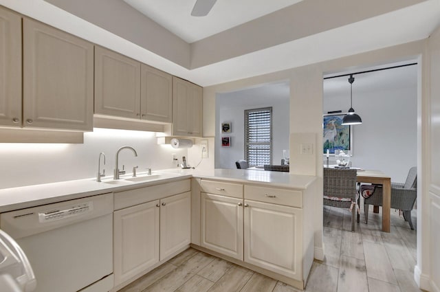 kitchen with light hardwood / wood-style flooring, kitchen peninsula, dishwasher, sink, and pendant lighting