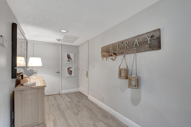 interior space featuring light hardwood / wood-style floors and a textured ceiling