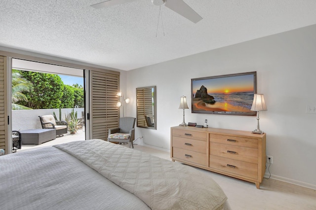 bedroom featuring light carpet, ceiling fan, and a textured ceiling