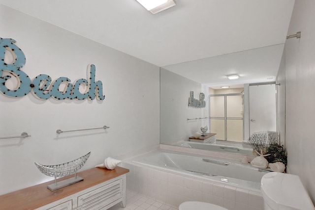 bathroom featuring tile flooring, tiled bath, and toilet