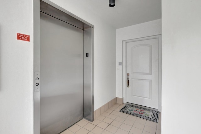 interior space featuring elevator and light tile flooring