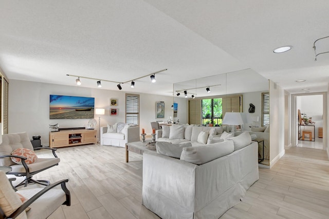 living room with a textured ceiling and rail lighting