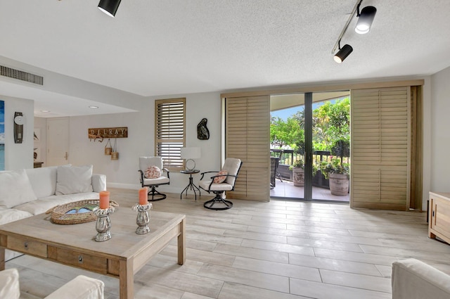 living room featuring a textured ceiling and rail lighting