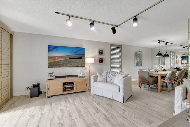 living room with a textured ceiling, hardwood / wood-style floors, and track lighting