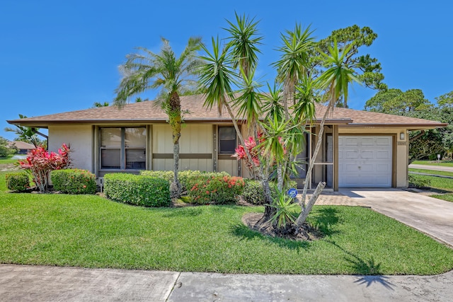 single story home with a garage and a front lawn