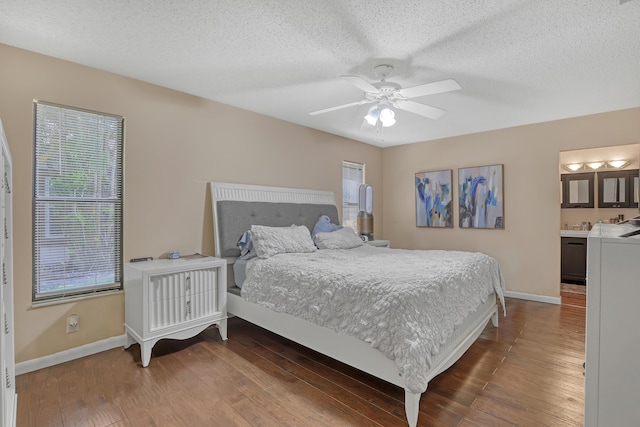 bedroom with wood-type flooring, ceiling fan, ensuite bathroom, and a textured ceiling