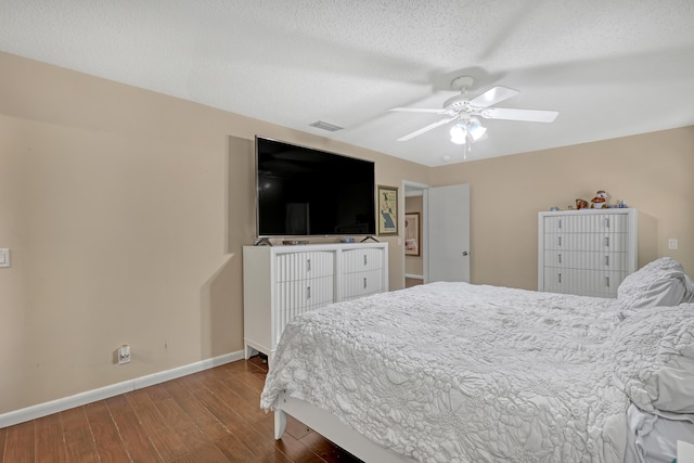 bedroom with ceiling fan, hardwood / wood-style flooring, and a textured ceiling