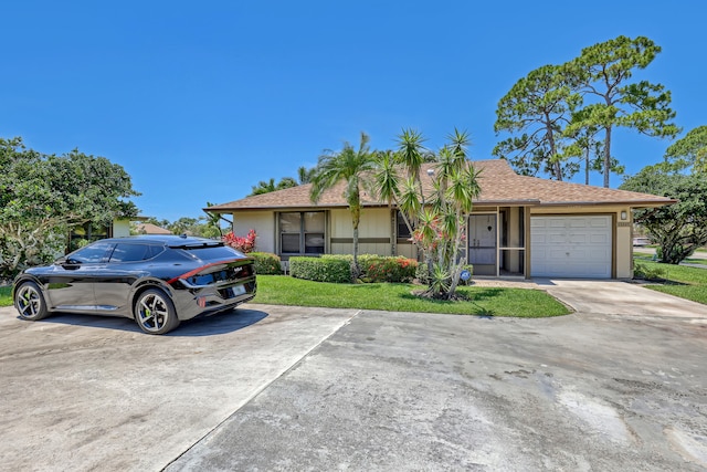 single story home featuring a garage and a front lawn