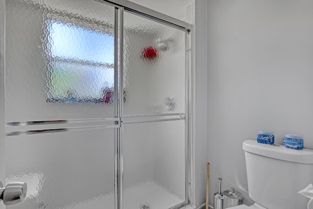 bathroom featuring walk in shower and toilet