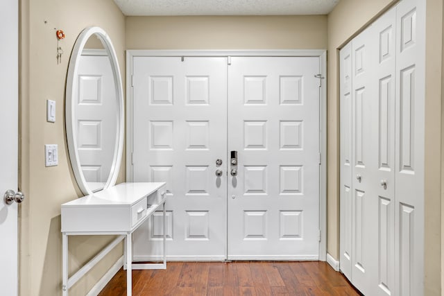 foyer featuring a textured ceiling and dark wood-type flooring