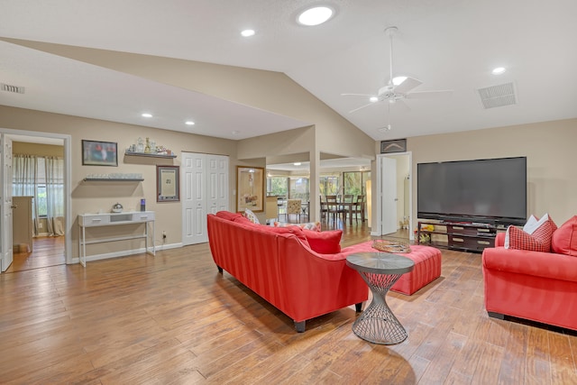 living room with wood-type flooring, vaulted ceiling, and ceiling fan