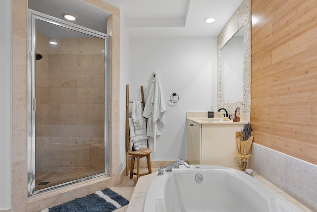 bathroom featuring wood walls, vanity, and plus walk in shower