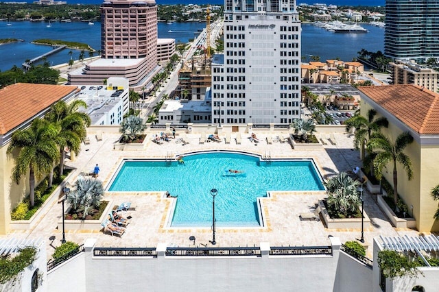 view of pool featuring a patio area and a water view