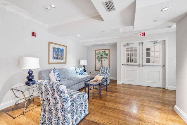 living room with ornamental molding and light hardwood / wood-style flooring