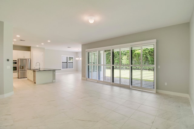 unfurnished living room featuring sink and light tile floors