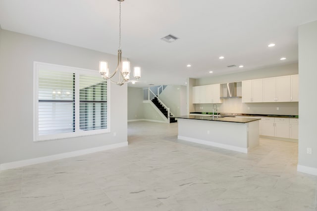 kitchen with an inviting chandelier, hanging light fixtures, white cabinetry, wall chimney exhaust hood, and light tile floors