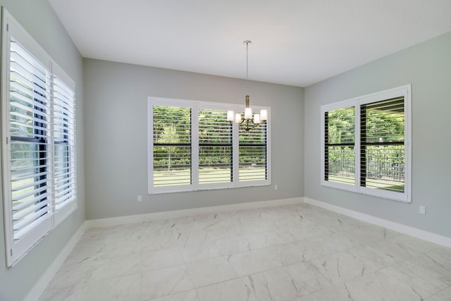 empty room featuring a chandelier, a wealth of natural light, and light tile floors