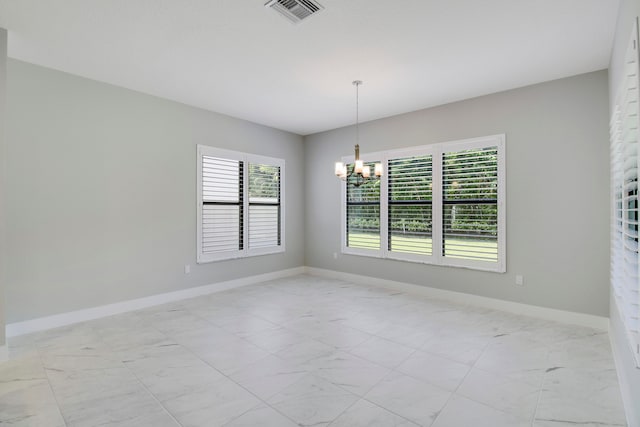 spare room featuring a notable chandelier and light tile floors