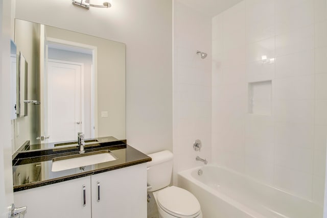 full bathroom with tiled shower / bath, vanity, and toilet