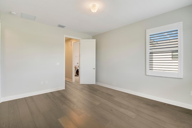 spare room featuring washer / dryer and dark hardwood / wood-style flooring