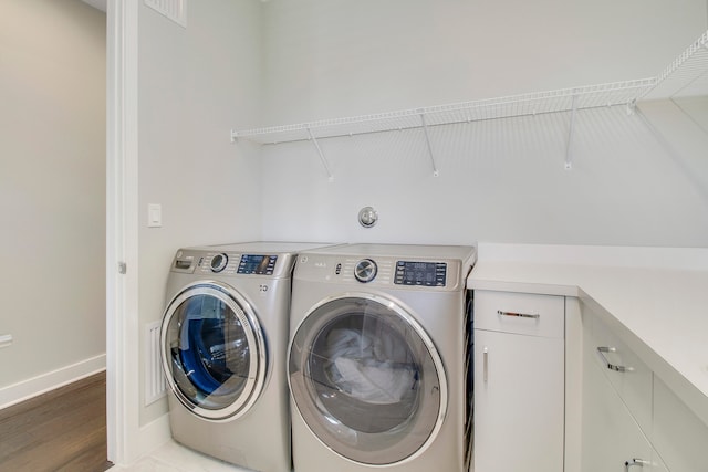 clothes washing area featuring separate washer and dryer and wood-type flooring