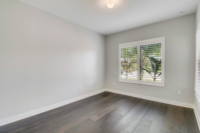 unfurnished room with dark hardwood / wood-style flooring