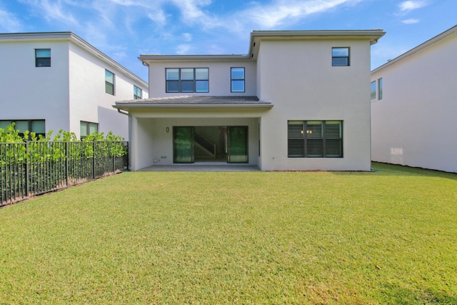 rear view of house with a patio area and a lawn