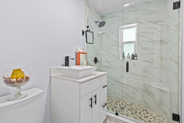 bathroom featuring toilet, a shower with door, and vanity