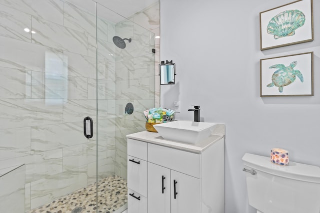 bathroom with toilet, a shower with shower door, and vanity