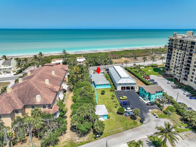 bird's eye view featuring a water view and a beach view