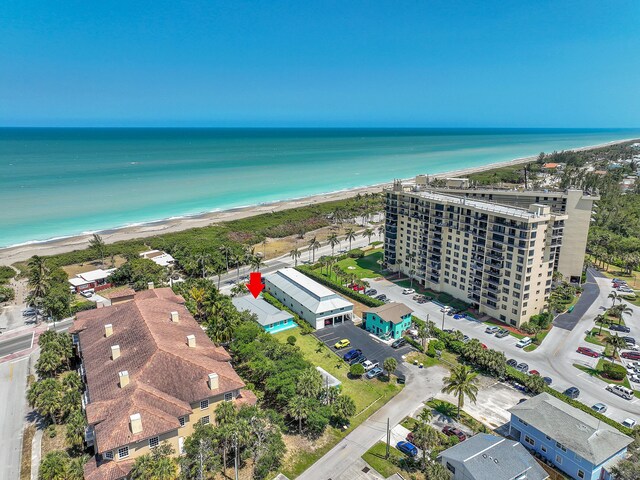 drone / aerial view with a water view and a beach view