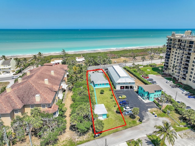 birds eye view of property featuring a water view and a beach view