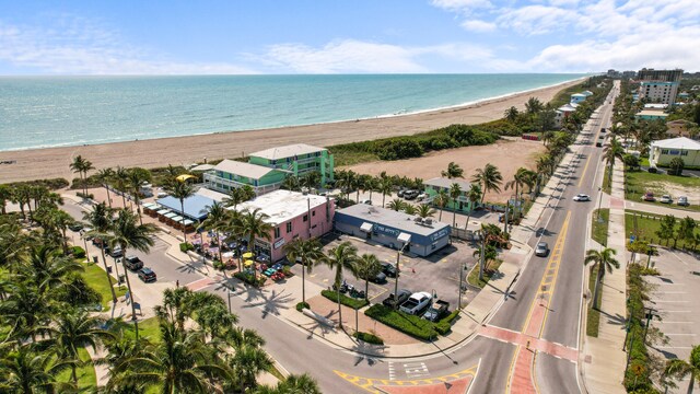 birds eye view of property featuring a water view and a beach view