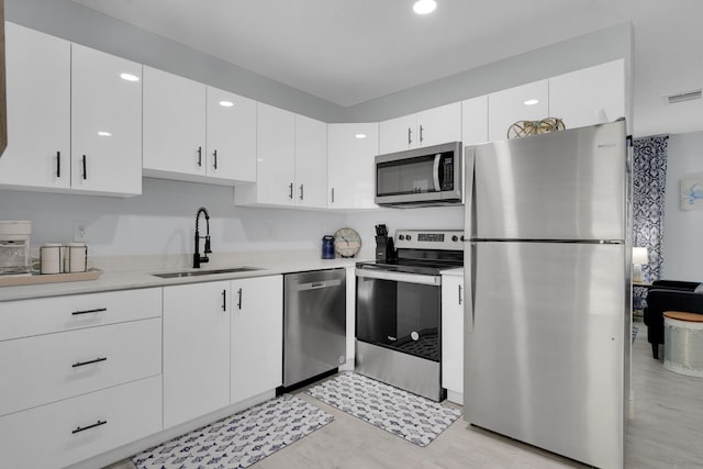 kitchen with sink, white cabinetry, and appliances with stainless steel finishes