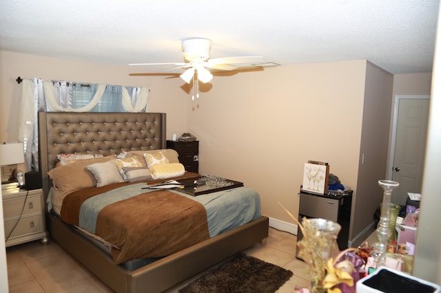 bedroom featuring a textured ceiling, light tile flooring, and ceiling fan