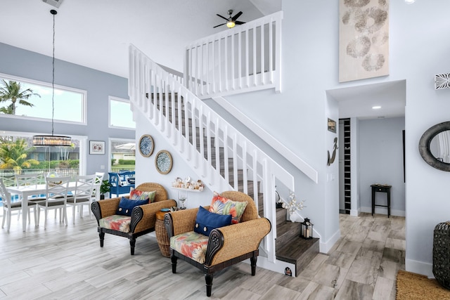 9029 SE Breeze Way, Hobe Sound, FL 33455 - living area with stairs, ceiling fan with notable chandelier, wood finished floors, a high ceiling, and baseboards
