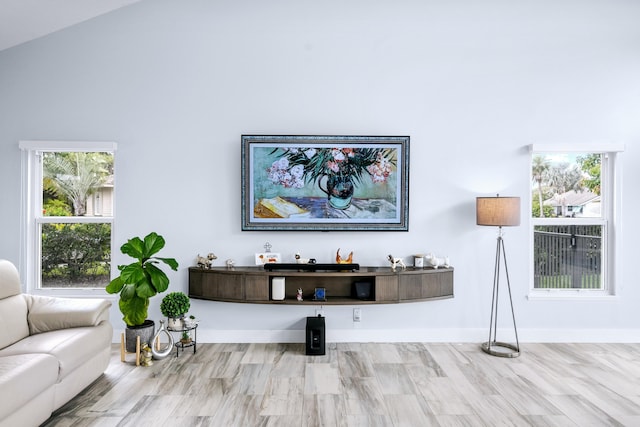 living room featuring high vaulted ceiling and light hardwood / wood-style floors