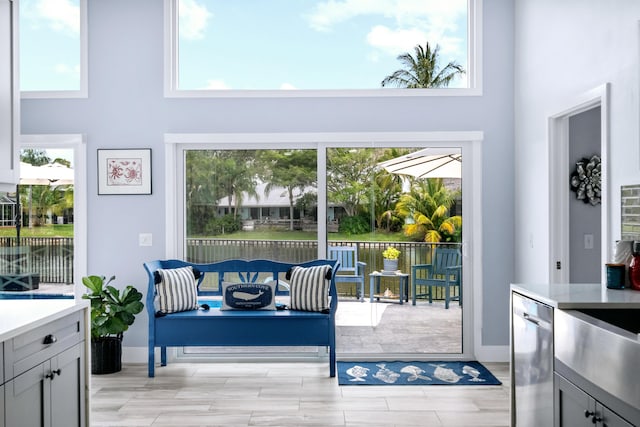 doorway to outside with a towering ceiling and plenty of natural light