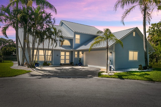 9029 SE Breeze Way, Hobe Sound, FL 33455 - modern farmhouse style home with fence, an attached garage, driveway, metal roof, and a standing seam roof
