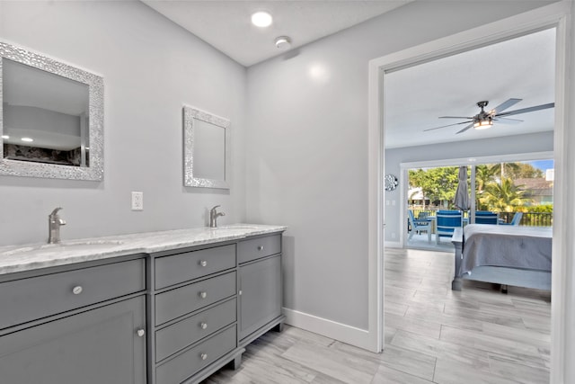 9029 SE Breeze Way, Hobe Sound, FL 33455 - ensuite bathroom featuring double vanity, baseboards, a ceiling fan, and a sink